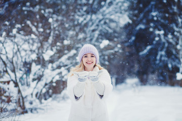 Fototapeta na wymiar Smiling woman playing with snow in park