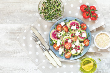 Healthy delicious tasty salad with tomatoes, radishes, cheeses, sprouts and sesame in plate