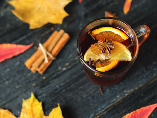 Hot mulled wine on a dark wooden table close-up