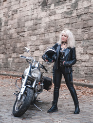 Fototapeta na wymiar Stylish blond woman with motorcycle outdoor. 