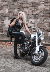 Beautiful woman posing on her motorcycle outdoor.
