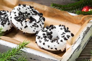 Donuts with white glaze in white box on wooden table