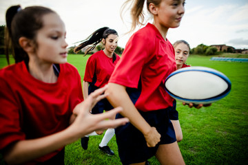 Female rugby players playing on the field