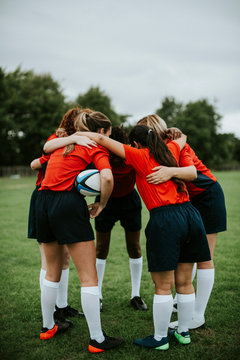 Young female rugby players huddling