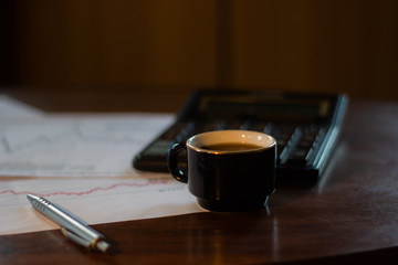 Morning cafe.On the table are graphs and a pen with a calculator.