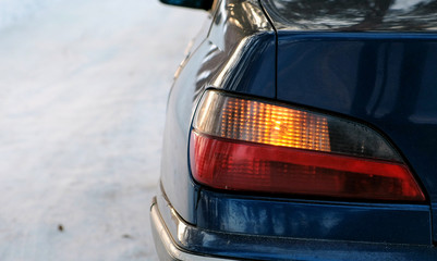 Close-up alarm flashes on the left side of the vehicle in winter park. Back view from the side.