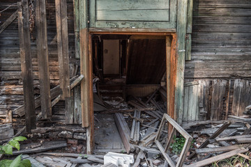Old ruined wooden house. Two-story building intended for demolition. Summer day