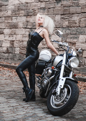 Fototapeta na wymiar Beautiful woman posing on her motorcycle outdoor. 