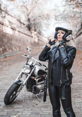 Naklejka premium Stylish blond woman with motorcycle outdoor. 