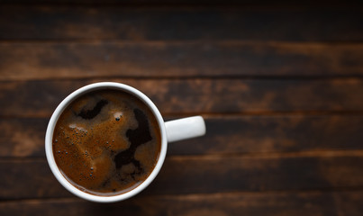 black coffee in white Cup on brown background
