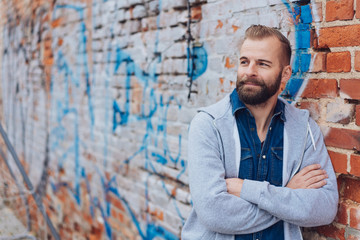 Relaxed trendy bearded man with folded arms