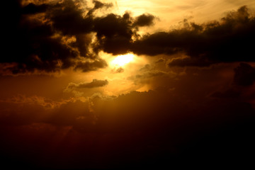 sunset at sea, red sun sits behind the horizon