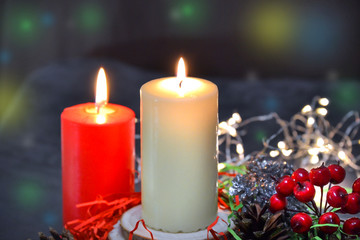 Christmas composition: red and white burning candles on a festive table on a dark background. Gingerbread, tinsel, festoon. Christmas, New Year, holiday