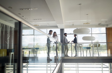 Group of business people walking and taking at stairs in an office