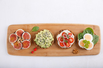 Different kinds of whole grain bread sandwiches on white background.