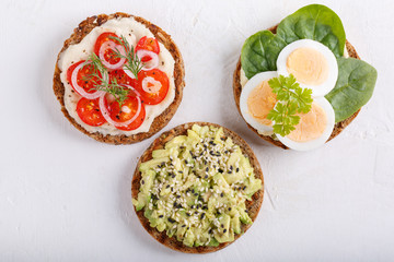Different kinds of whole grain bread sandwiches on white background.