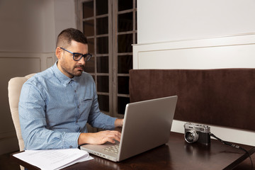 Hombre de negocios escribiendo en su ordenador personal en cafetería