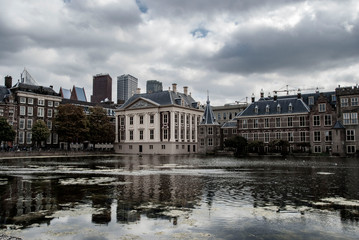 kyline of The Hague with the modern office buildings behind the Mauritshuis museum and the Binnenhof parliament building next to Hofvijver lake. 