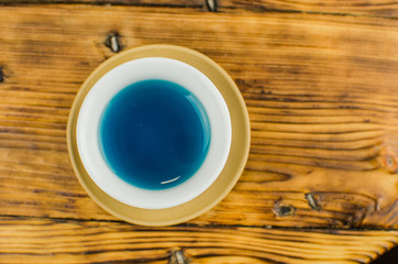 Organic blue tea Anchan in a teapot and a cups on wooden background