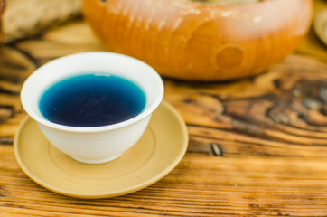 Organic blue tea Anchan in a teapot and a cups on wooden background