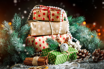 Merry Christmas and happy New year. Christmas gift and Christmas tree on dark wooden background. Selective focus.