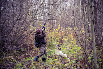 male hunter, in the forest, with arms, dog Springer Spaniel, hunting, autumn