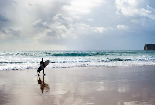 Surfer surfboard walking beach Portugal