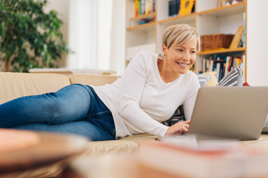 Attractive woman relaxing on a sofa using a laptop