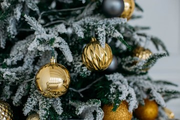  Christmas tree with yellow festive balls and artificial decorative snow