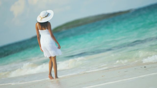 Ethnic Hispanic female in white dress on vacation ocean beach