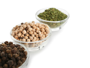 Glass bowls with different spices on white background