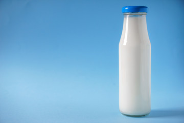 Bottle of milk on color background