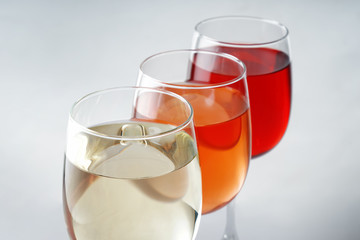 Glasses of different wine on white background