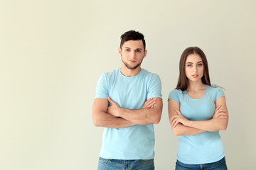 Young man and woman in stylish t-shirts on white background