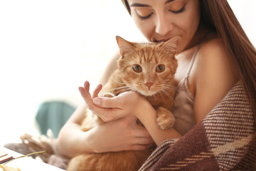 Woman with cute cat resting at home
