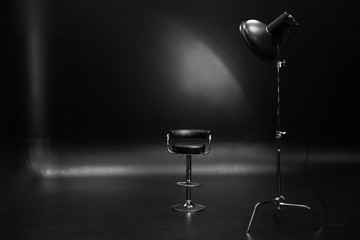 Professional lighting equipment with chair on dark background
