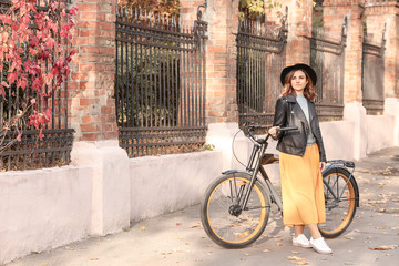 Fototapeta premium Beautiful young woman with bicycle outdoors