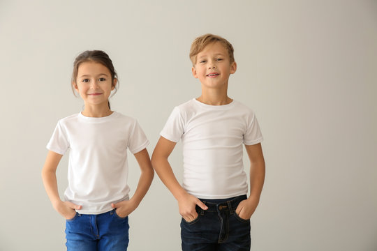 Cute children in t-shirts on light background