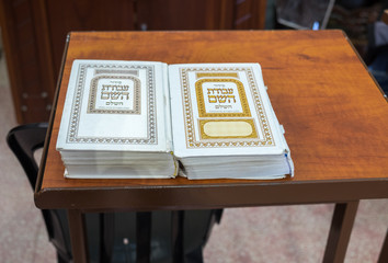 Jewish holy books "Siddur" on wooden stand at synagogue in Cave of Machpelah in Hebron or Tomb of the Patriarchs. Israel © vadiml