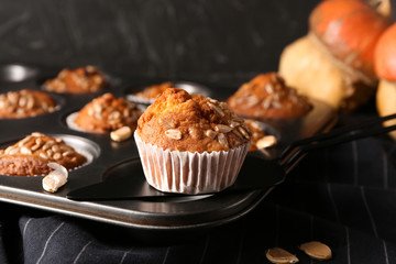 Tasty pumpkin muffin with sunflower seeds on baking form