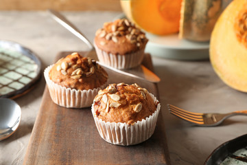 Delicious pumpkin muffins with sunflower seeds on table