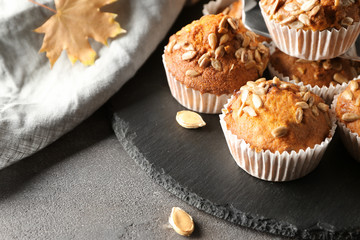 Delicious pumpkin muffins with sunflower seeds on table