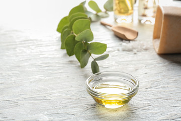 Glass bowl of eucalyptus essential oil on white table