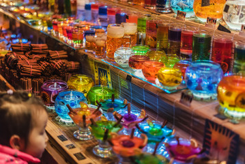 Vienna, Austria - December 24, 2017. Christmas Color Jelly Glass Gel Candles and cinnamon sticks in kiosk at Viennese Christmas market. Xmas fair stall selling handmade craft souvenirs and gifts.