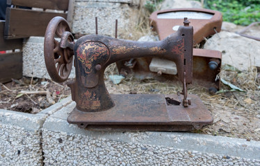 Retro rusted sewing machine and scales on backyard