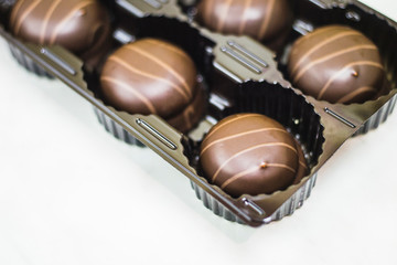 Candy cane in packaging. Chocolate dessert on a light table.