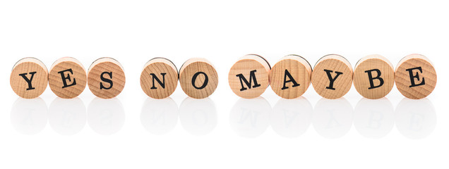 Words Yes No Maybe from circular wooden tiles with letters.