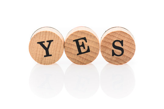 Word Yes from circular wooden tiles with letters children toy. - Powered by Adobe