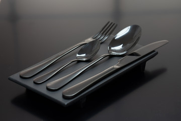 Cutlery spoon, fork and knife on black background