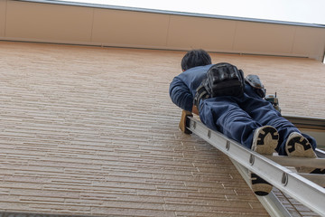 梯子に登る作業員